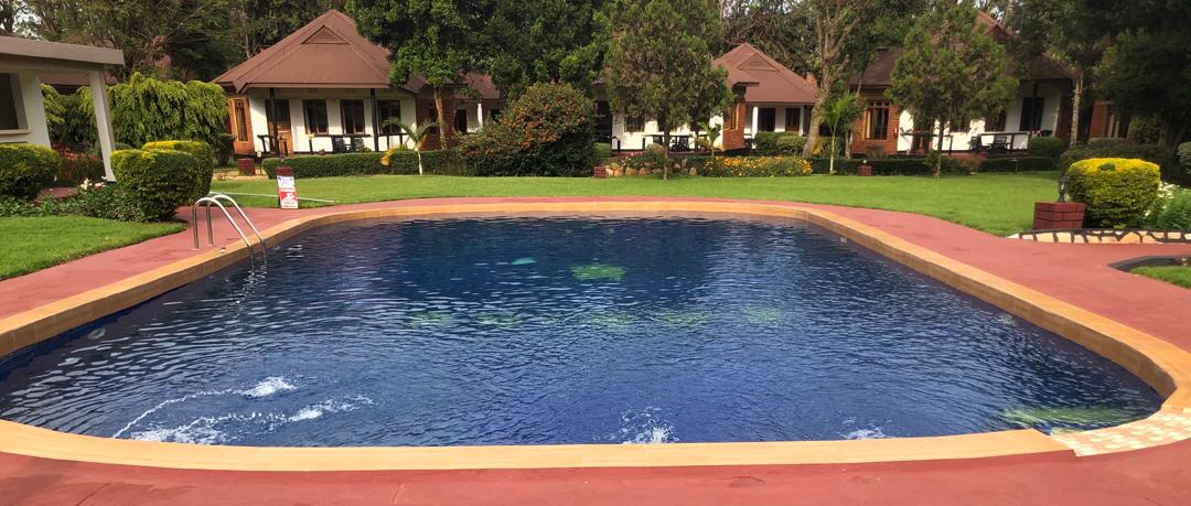 Large swimming pool with cottages in background